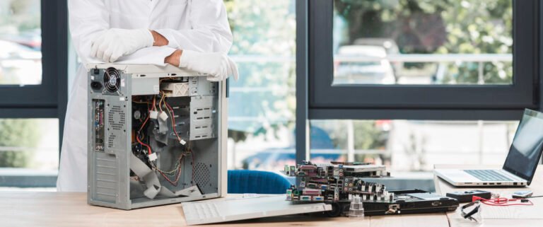 portrait-happy-male-technician-with-broken-computer