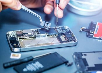 Technician repairs the damaged mobile phone. Serviceman is repairing a damaged cell phone. Technician repairs the damaged smartphone. serviceman repairs the damaged camera on the smartphone.